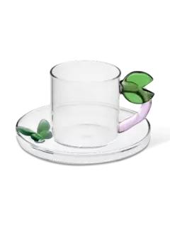 كوب قهوة بصحن مزين بأوراق شجر