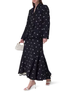 تنورة طويلة من قماش الجاكار بقصة ضيقة من الأعلى وواسعة من الأسفل مزينة بزهور صغيرة