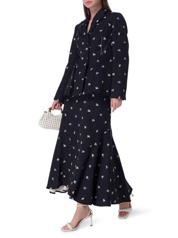 تنورة طويلة من قماش الجاكار بقصة ضيقة من الأعلى وواسعة من الأسفل مزينة بزهور صغيرة