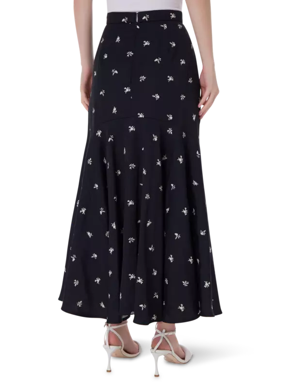 تنورة طويلة من قماش الجاكار بقصة ضيقة من الأعلى وواسعة من الأسفل مزينة بزهور صغيرة